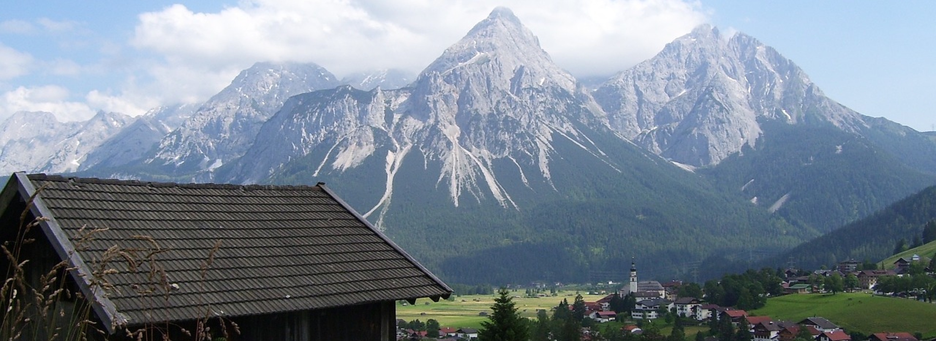 Snow-covered peaks of the Alps rising above a small village in Europe.