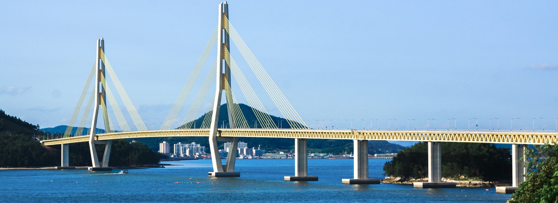 Gwangan Bridge spanning the water in Busan South Korea with mountains and city in background.