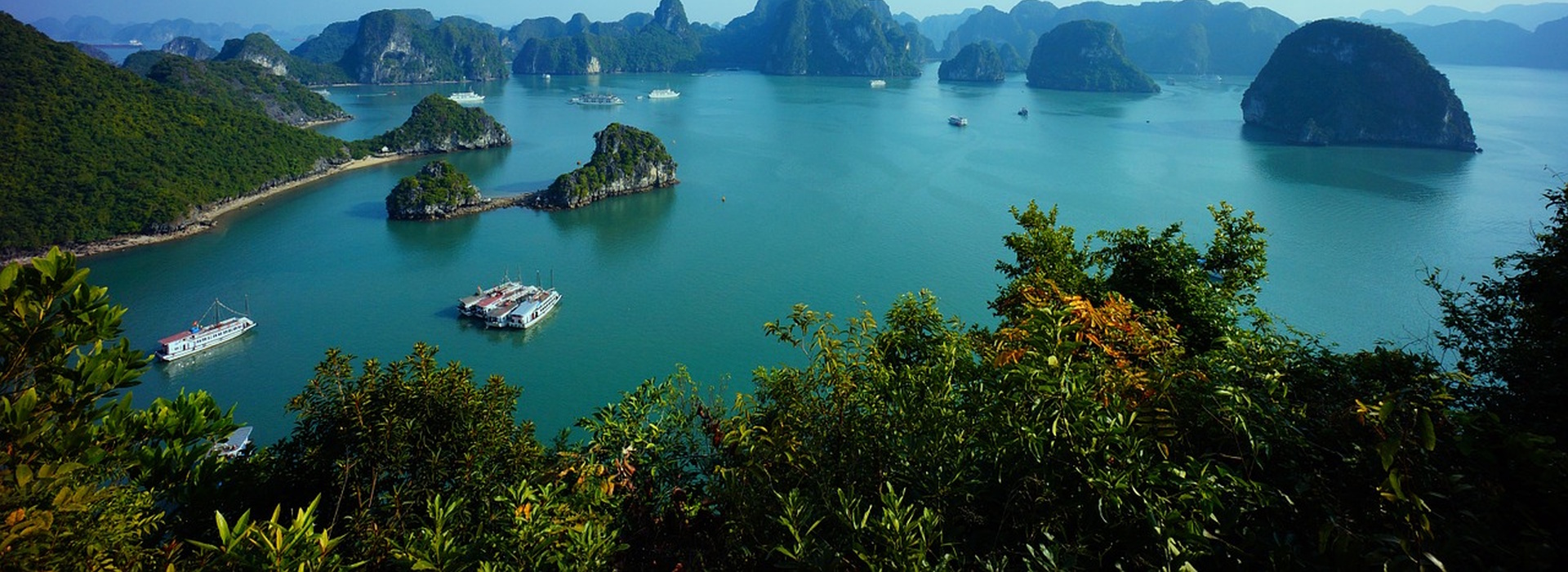 Ha Long Bay in Vietnam with limestone islands and boats on turquoise water.