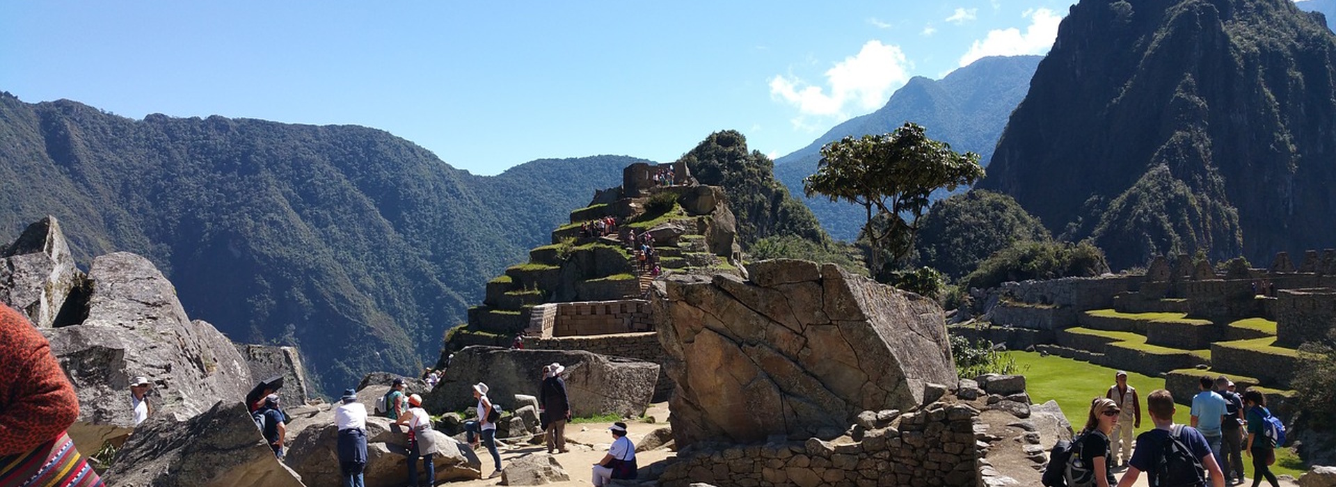 Machu Picchu ruins in the Andes Mountains of Peru with visitors exploring the ancient Incan city.