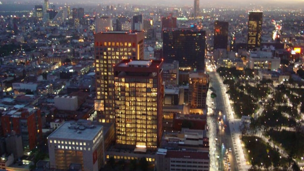 Aerial view of the Mexico City skyline with modern skyscrapers and city lights at dusk
