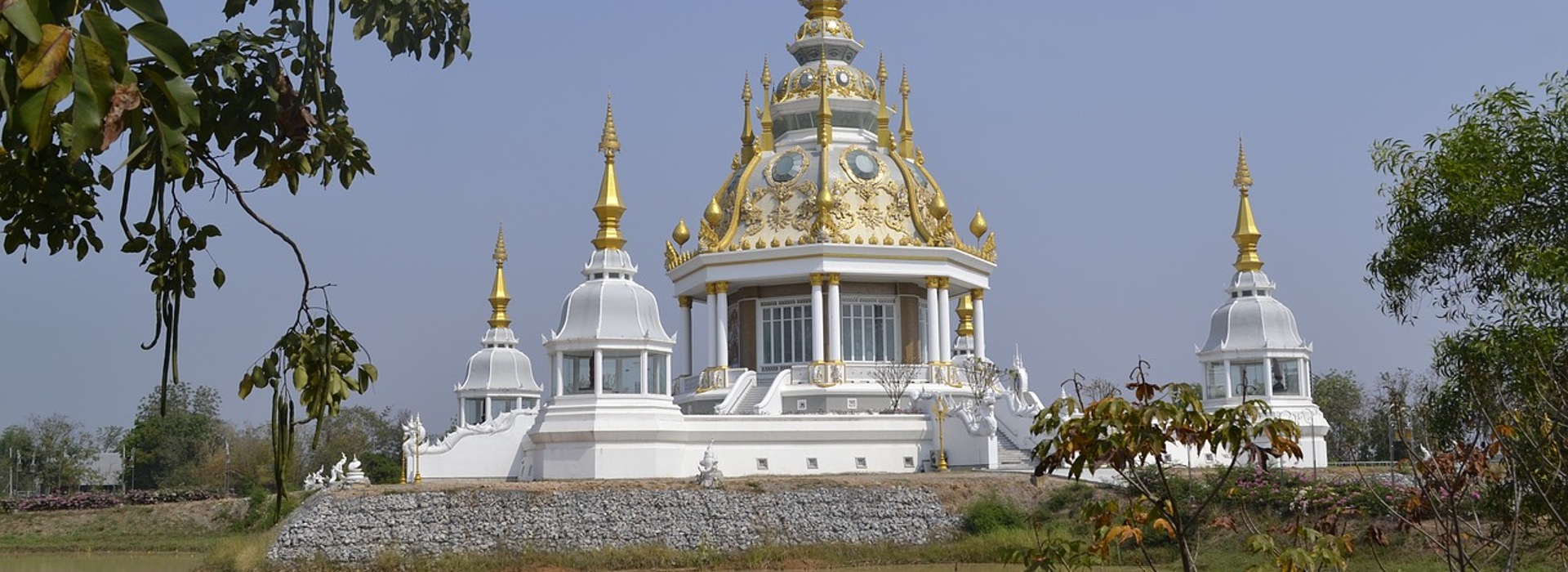 White and gold Thai temple with ornate architecture in Thailand.