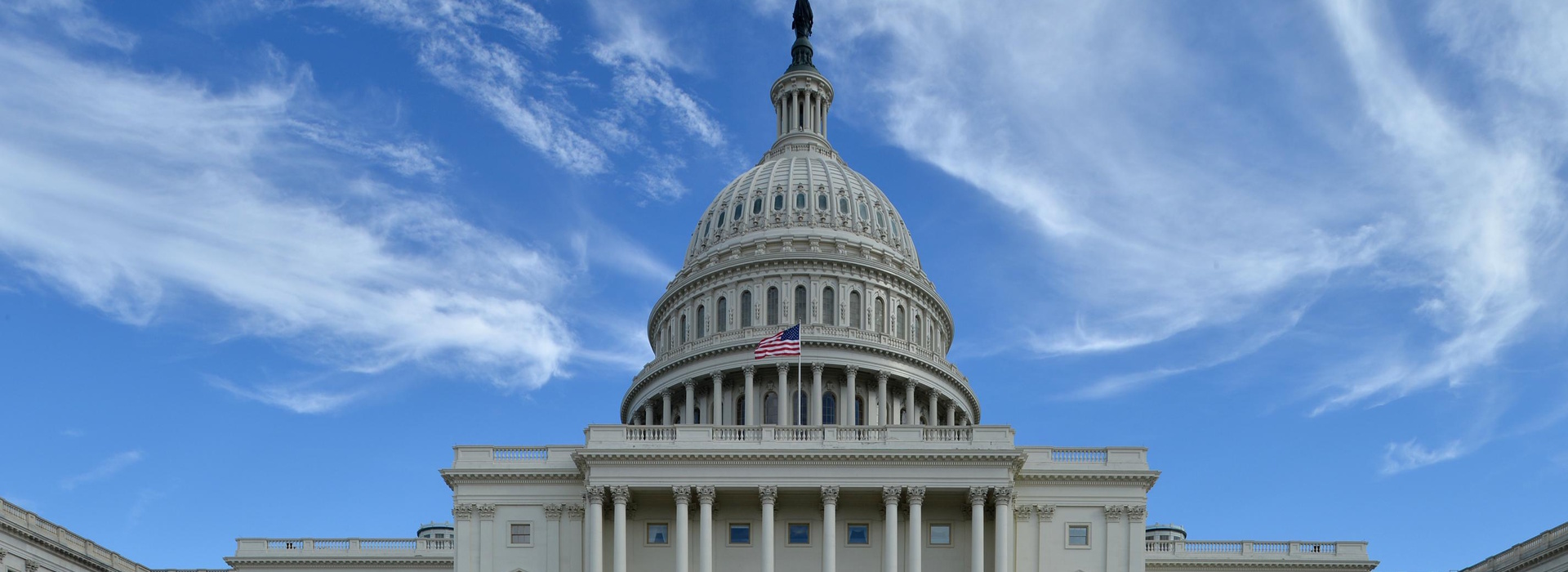 United States Capitol building dome in Washington DC under blue sky