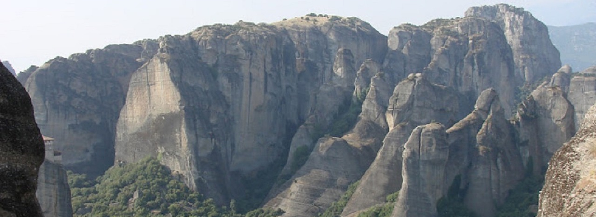 Meteora rock formations in Greece with steep cliffs and monasteries on top.